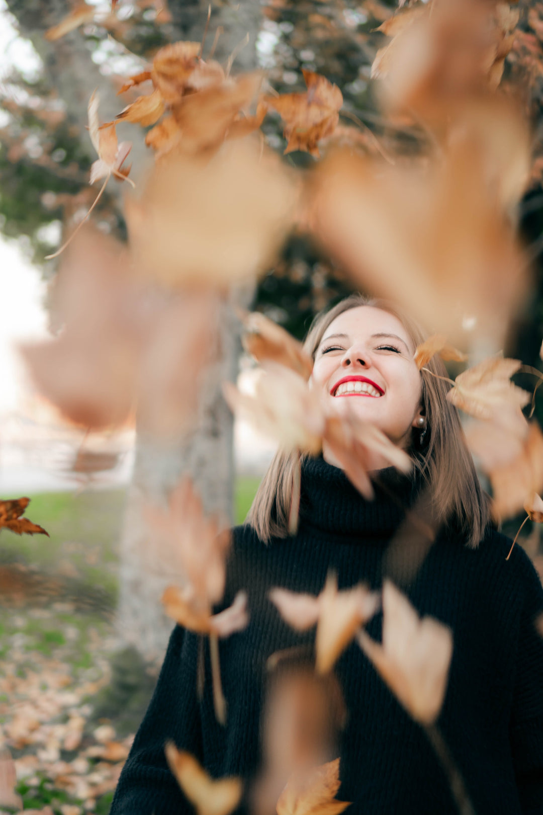 Woman smiling with autumn leaves