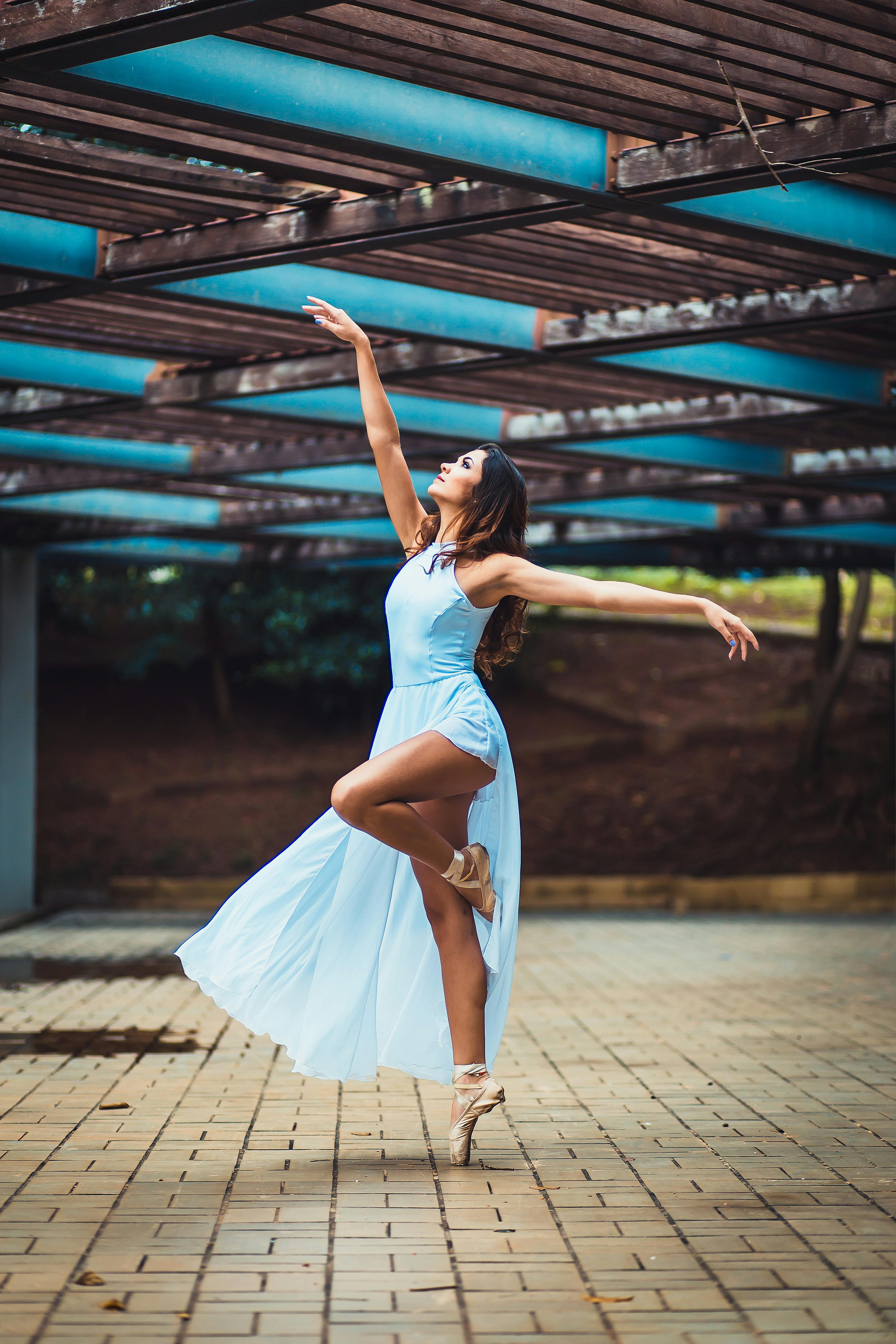 Woman doing a ballet pose in a blue dress
